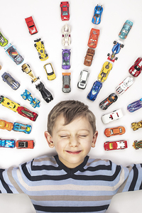 portrait of Caucasian child with toy cars 
