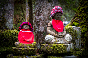 funerary statues with red decorations in the Okunoin cemetery 