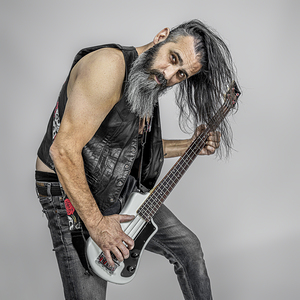 man with long hair playing the electric bass guitar.