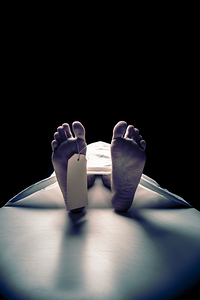 close-up of a dead mans feet on the mortuary table