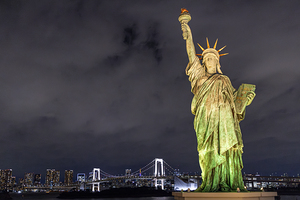 The statue of liberty is standing tall in odaiba tokyo at night