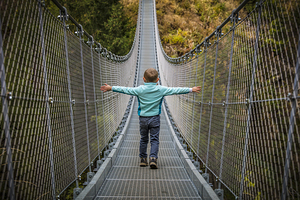 kid on suspended bridge 