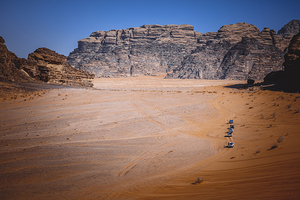 column of 4x4 cars in the wadi rum desert.