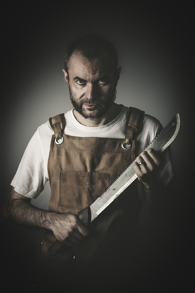 dramatic portrait of a killer holding a machete by Gualtiero Boffi