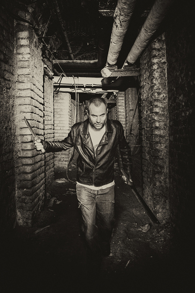 serial killer holding knives and running inside an underground t