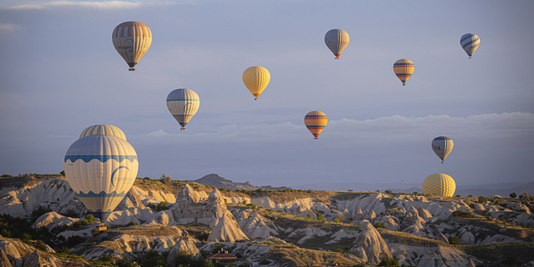 colorful hot air balloons fly at sunrise near goreme Print