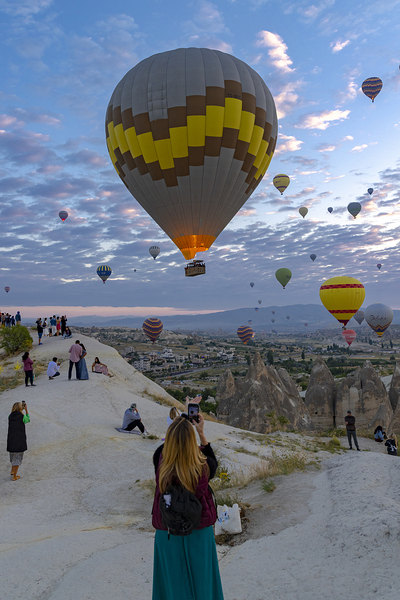 hot air balloon flies near the tourists .