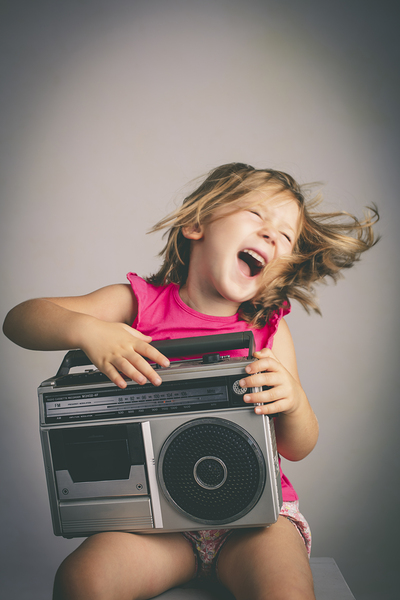 little girl has fun listening to music 