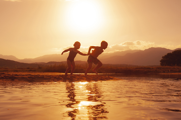 children run happily on the beach  by Gualtiero Boffi