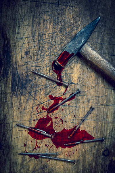 hammer and bloody nails on a wooden