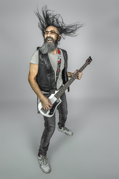 man with long fluttering hair plays bass guitar
