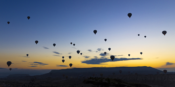 hot air balloons take off at sunrise over the city of goreme 