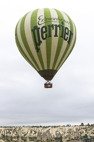 hot air balloon with Perrier lettering flies over the city of go Print