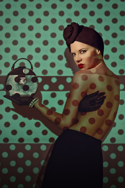 Beautiful young woman from the 20s wearing a turban and holding a small round purse a polka dot pattern projected onto her body and background by Artmood Visualz