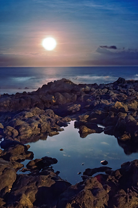 Black lava tidepool with full moon Ka Iwi Hawaii