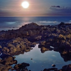 Black lava tidepool with full moon Ka Iwi Hawaii
