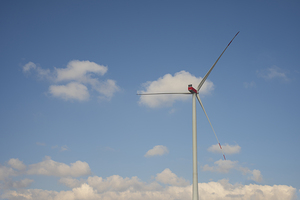 A wind turbine with a blue sky and clouds.  Concept of clean energy.