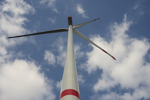 A wind turbine with a blue sky and clouds.  Concept of clean energy.