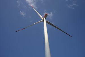 A wind turbine with a blue sky and clouds.  Concept of clean energy.