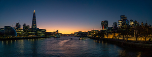 London Tower bridge with surrounding skyscrapers of the downtown at dusk