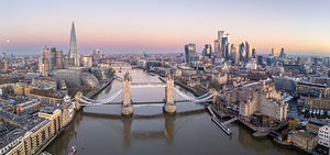 London Tower bridge with surrounding skyscrapers of the downtown at dawn