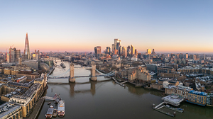 London Tower bridge with surrounding skyscrapers of the downtown at dawn