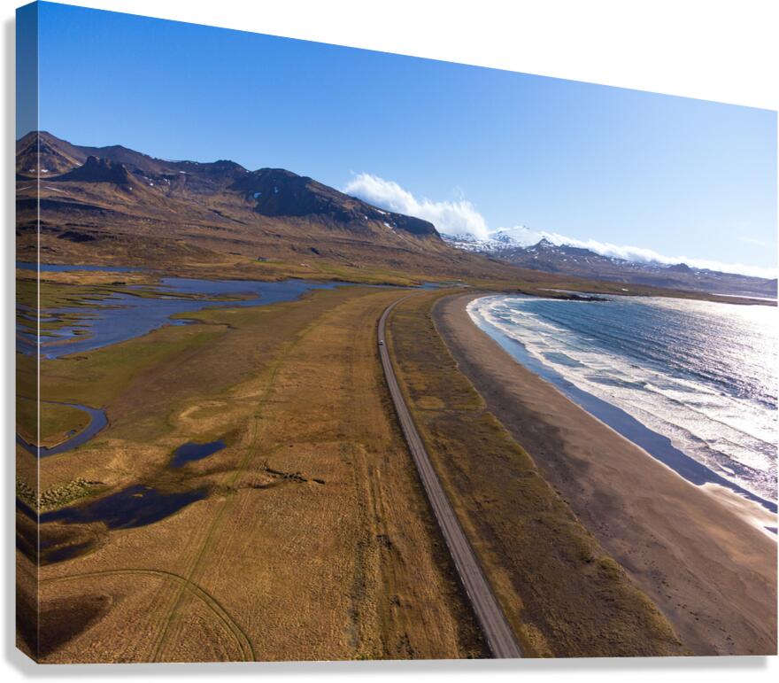 Iceland scenic route Snaefellsnes pensinsula volcano in the background covered in snow empty road with the ocean and waves. Canvas Print