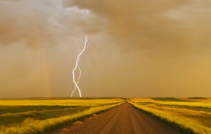 Storm Over Gravel Road Between Farmland 