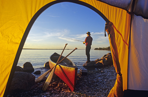 Boy Fishing Next to Tent 