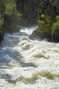 hiker on foot bridge at Wekusko Falls