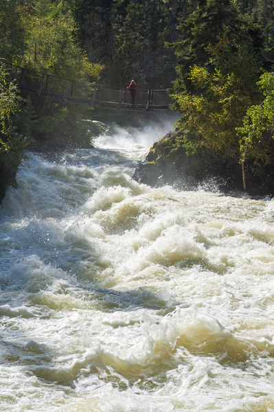 hiker on foot bridge at Wekusko Falls by Dave Reede Photohgraphy