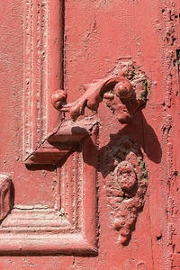 Vintage wooden door with shriveled red paint