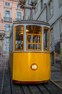 Yellow funicular on a steep hill in Lisbon - PORTUGAL