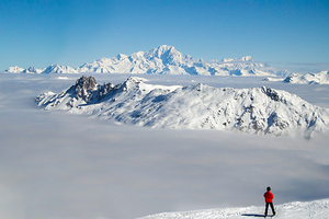 Beyond the clouds skier and the Mont Blanc in the Alps
