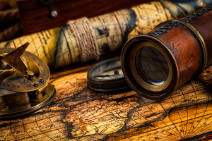 Old vintage compass and navigation instruments on ancient map