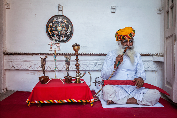 Old Indian man smokes hookah waterpipe in Mehrangarh fort by Dmitry Rukhlenko