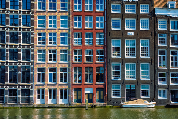 houses and boat on Amsterdam canal Damrak with reflection. Ams by Dmitry Rukhlenko