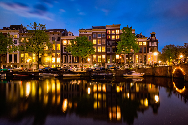Amsterdam canal bridge and medieval houses in the evening Netherlands by Dmitry Rukhlenko