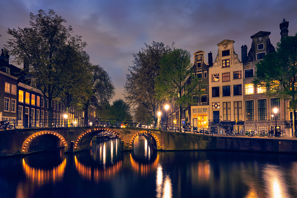Amsterdam canal bridge and medieval houses in the evening Netherlands by Dmitry Rukhlenko