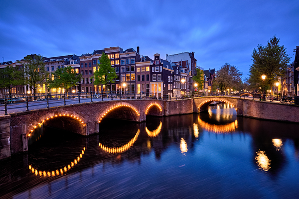 Amsterdam canal bridge and medieval houses in the evening Netherlands by Dmitry Rukhlenko