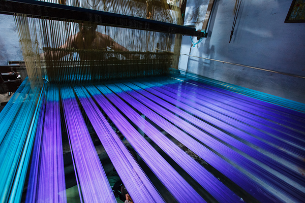 Man weaving silk sari on loom. Kanchipuram is famous for hand woven silk sarees by Dmitry Rukhlenko