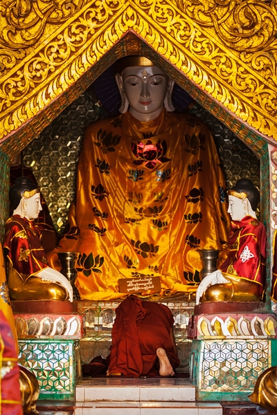 Buddhist monk praying in Shwedagon pagoda by Dmitry Rukhlenko
