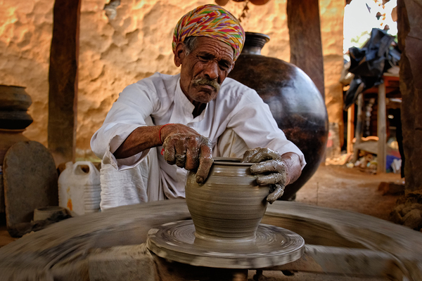 Indian potter at work. Handwork craft from Shilpagram Udaipur Rajasthan India by Dmitry Rukhlenko