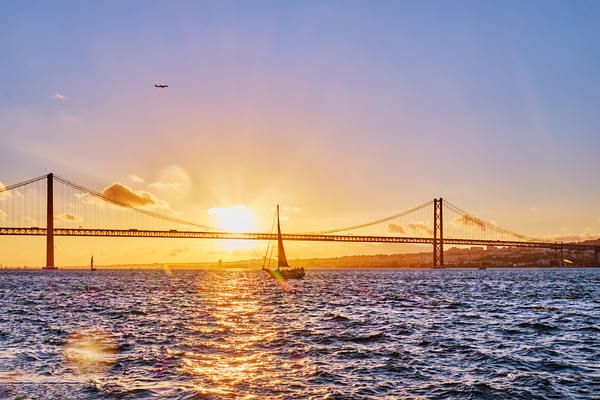 View of 25 de Abril Bridge over Tagus river on sunset. Lisbon Portugal by Dmitry Rukhlenko