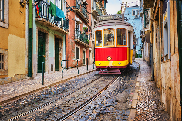 Famous vintage yellow tram 28 in the narrow streets of Alfama district in Lisbon Portugal by Dmitry Rukhlenko