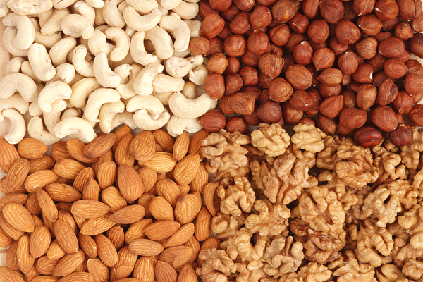 Different nuts almons cashews walnuts and filbers close up by Dmitry Rukhlenko