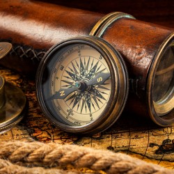 Old vintage compass and navigation instruments on ancient map