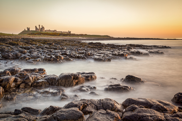Sunrise at Dunstanburgh Castle Northumberland by Travelling Light