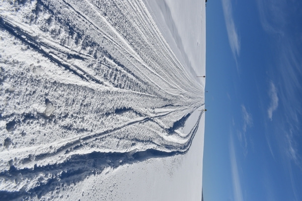 A snowmobile trail in a field by Laprise