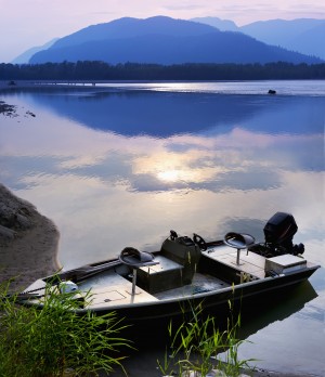 Boat moored on the Peg Leg Bar at sunset; Chilliwack, British Columbia, Canada